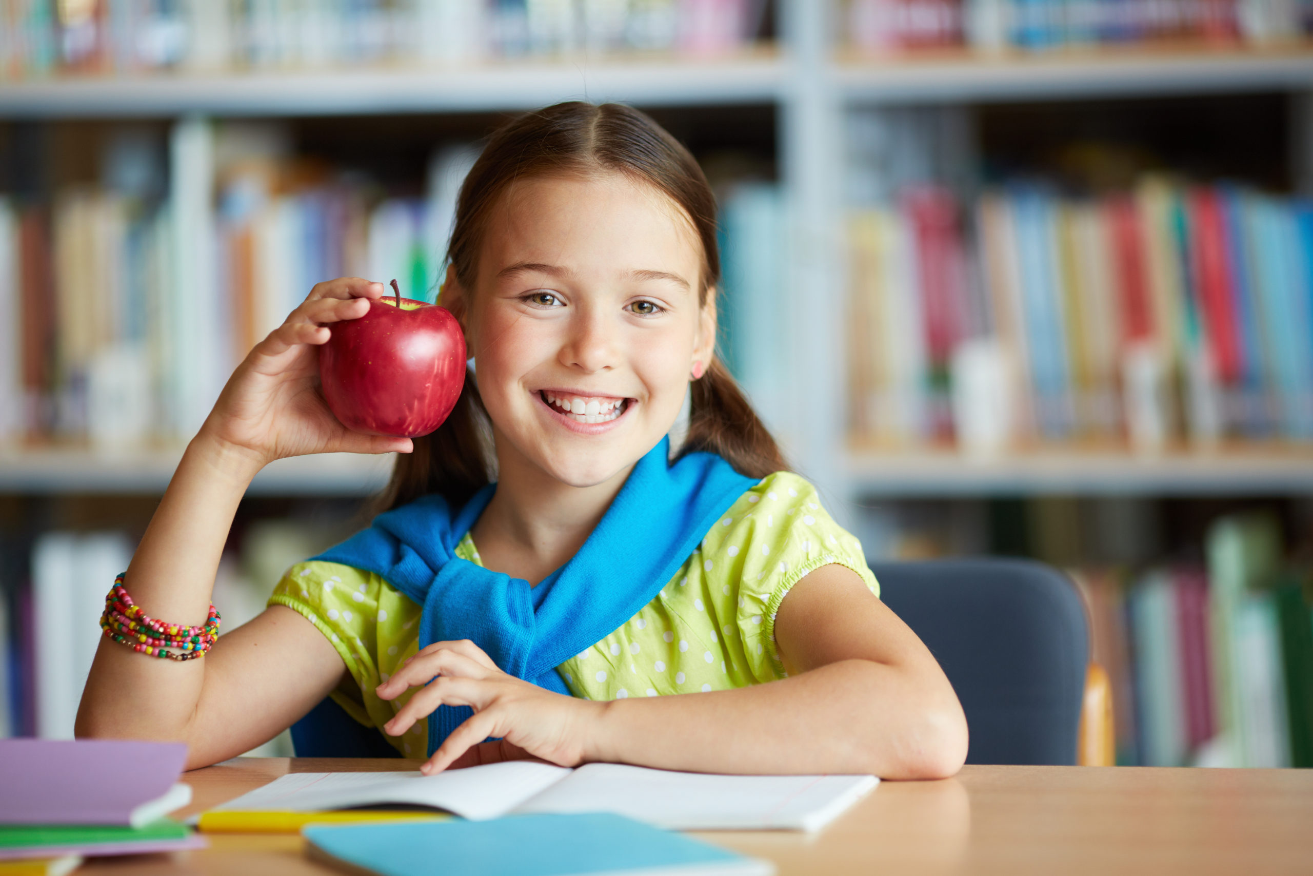Bambina sorridente con una mela in mano